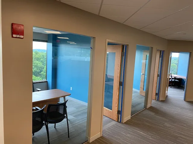 Commercial glass-walled office suite with blue accent wall