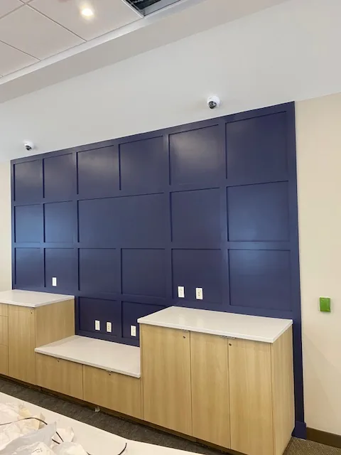 Commercial navy paneled accent wall with wood cabinetry