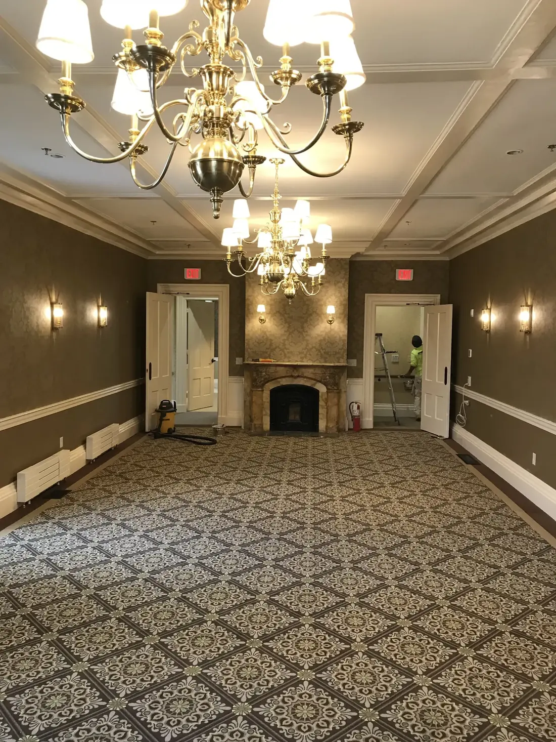 Finished event hallway with chandeliers and marble fireplace