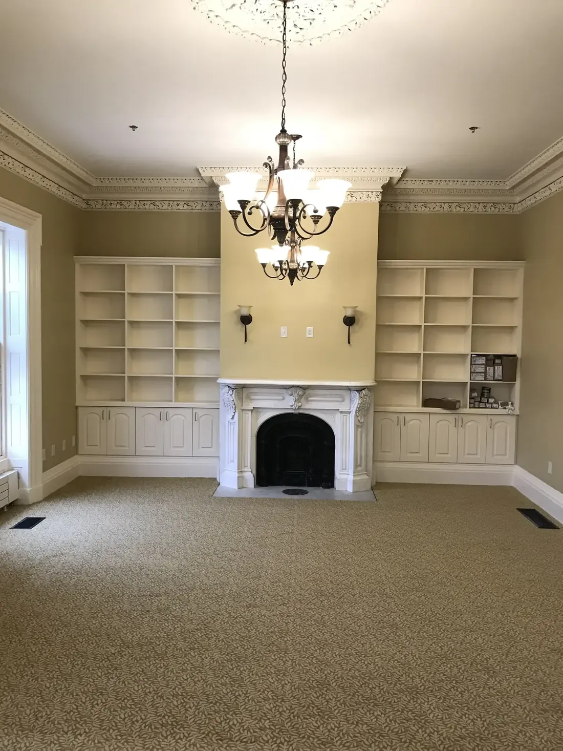 Historic room with painted built-in bookshelves and marble fireplace