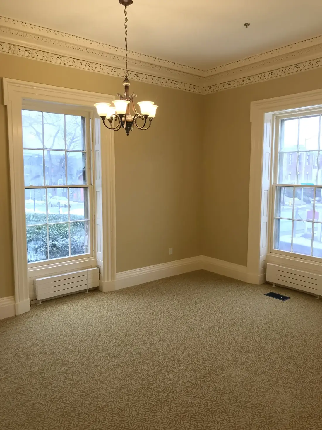 Historic room with finished trim, crown molding, and windows