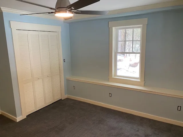 Blue residential bedroom with closet and ceiling fan