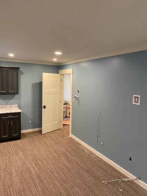 Blue-gray residential room with dark wood cabinet