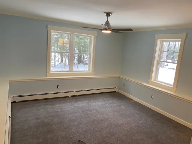 Finished blue residential room with ceiling fan and windows